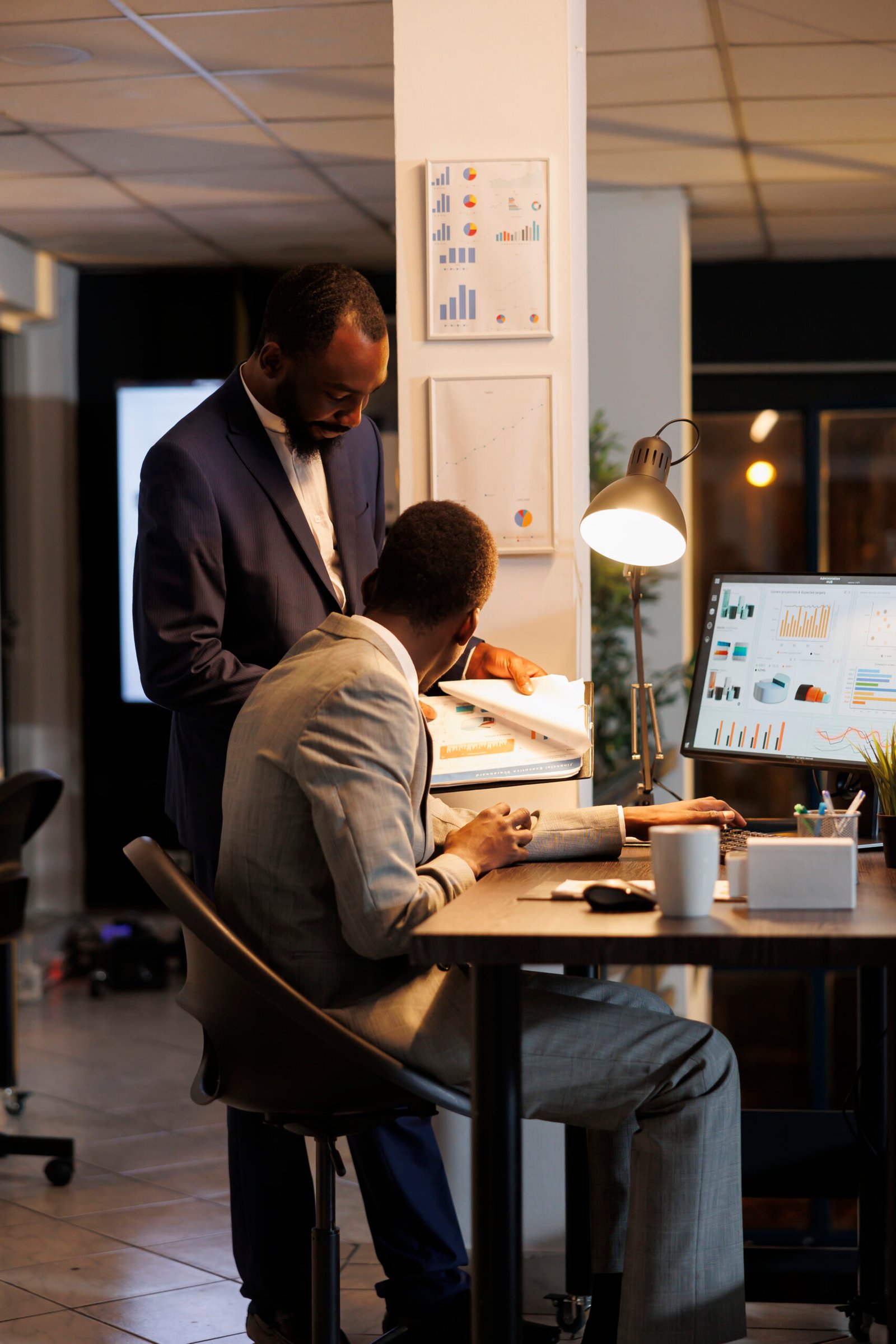 Employees looking at financial statistics on computer
